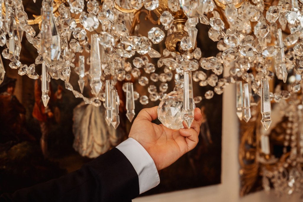 Éric Benhamou examine les pendeloques d'un lustre en cristal