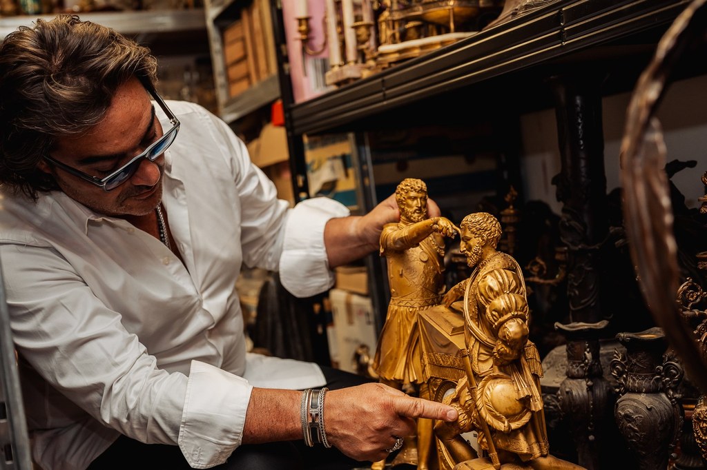Éric Benhamou examine le mécanisme d'une pendule ancienne