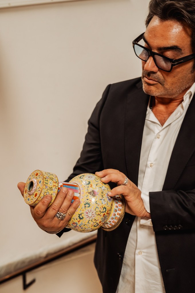 Éric Benhamou examine un vase chinois ancien