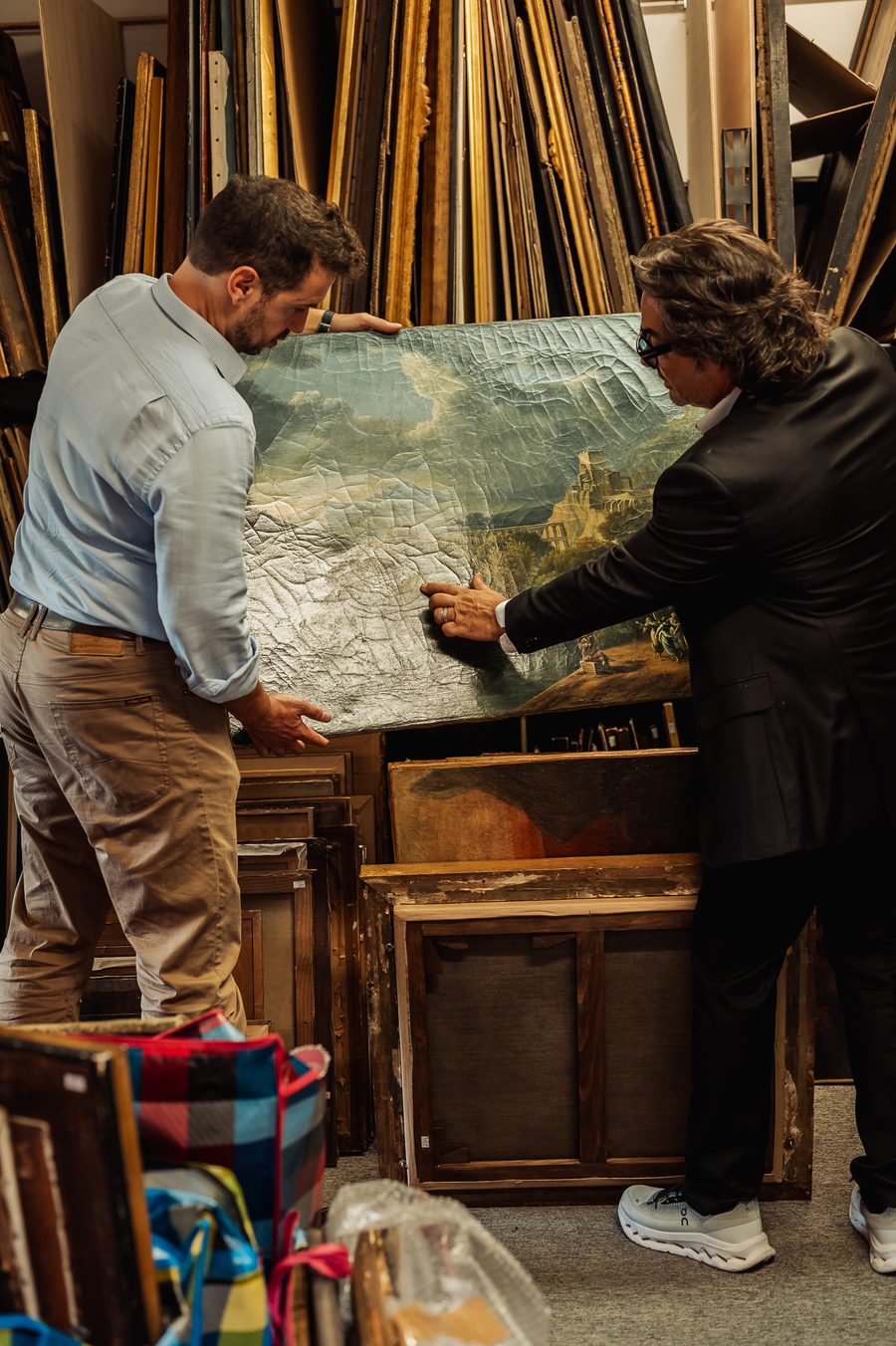 Examen d'une toile de paysage ancienne dans la réserve des tableaux